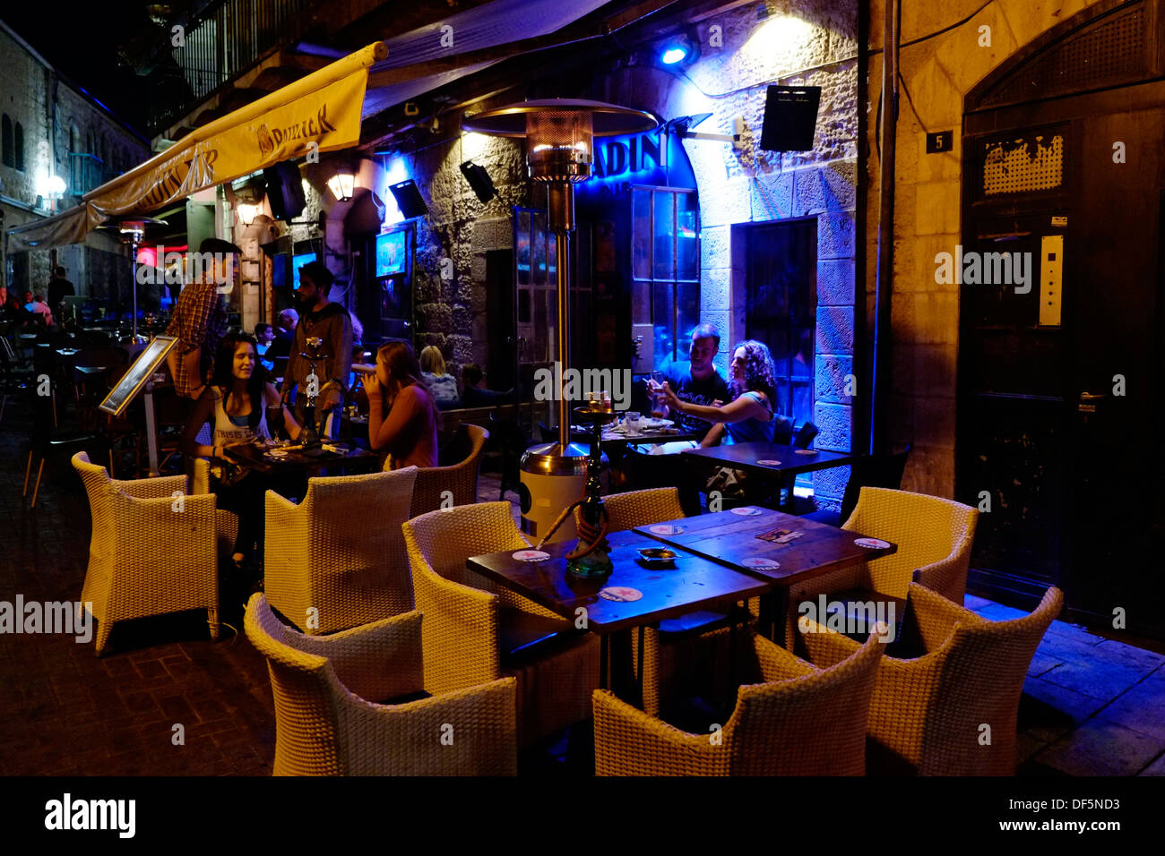 Persone che siedono all'aperto in bar allineati in Rivlin Street in Nahalat Shiva un antico quartiere cortile nel centro di Gerusalemme Ovest Israele Foto Stock