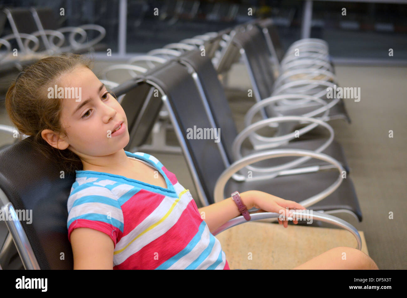 Ragazza in aeroporto - annoiato ragazza adolescente in attesa per il suo volo all'aeroporto Foto Stock