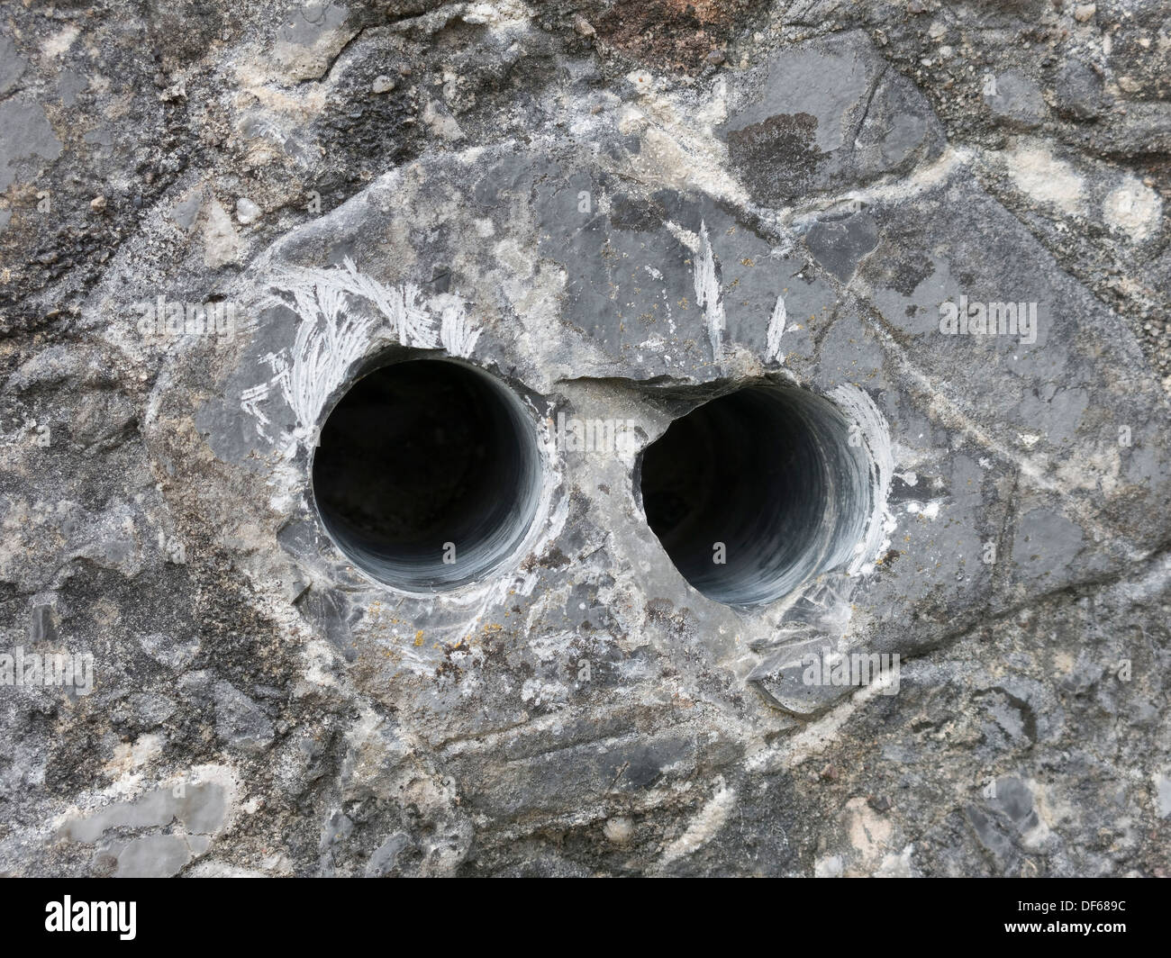 Geologia carota trapanare i fori nel budino di conglomerato di pietra rock, Boreraig, Isola di Skye, Scotland, Regno Unito. Foto Stock