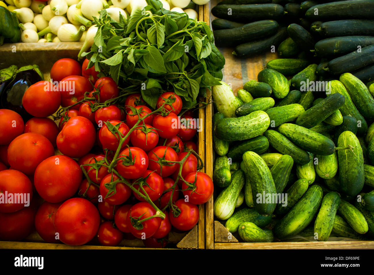 Vari ortaggi in stallo del mercato, compresi i pomodori e le zucchine, la cipolla, il basilico e melanzane Foto Stock
