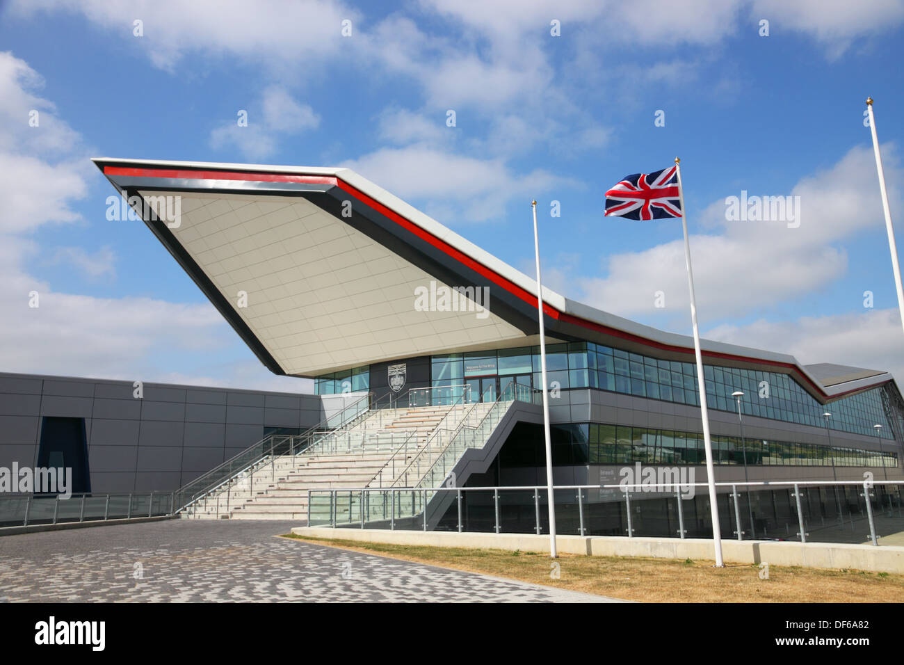 L'ala costruzione presso il circuito di Silverstone con Union Jack flag battenti contro un cielo blu. Foto Stock