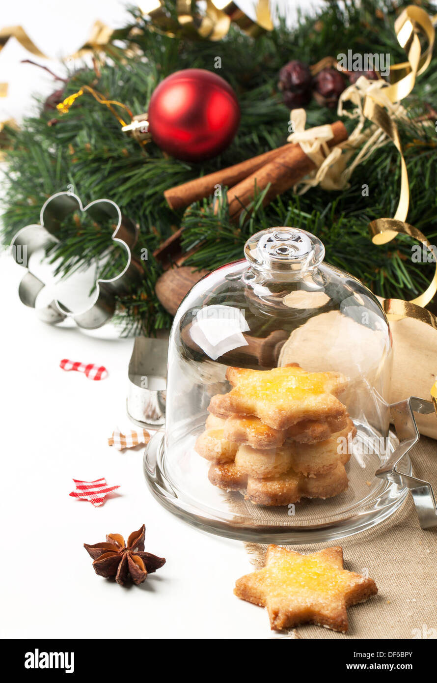 Lo zucchero in casa biscotti serviti nel vassoio di vetro con tappo vicino albero di natale su bianco Foto Stock