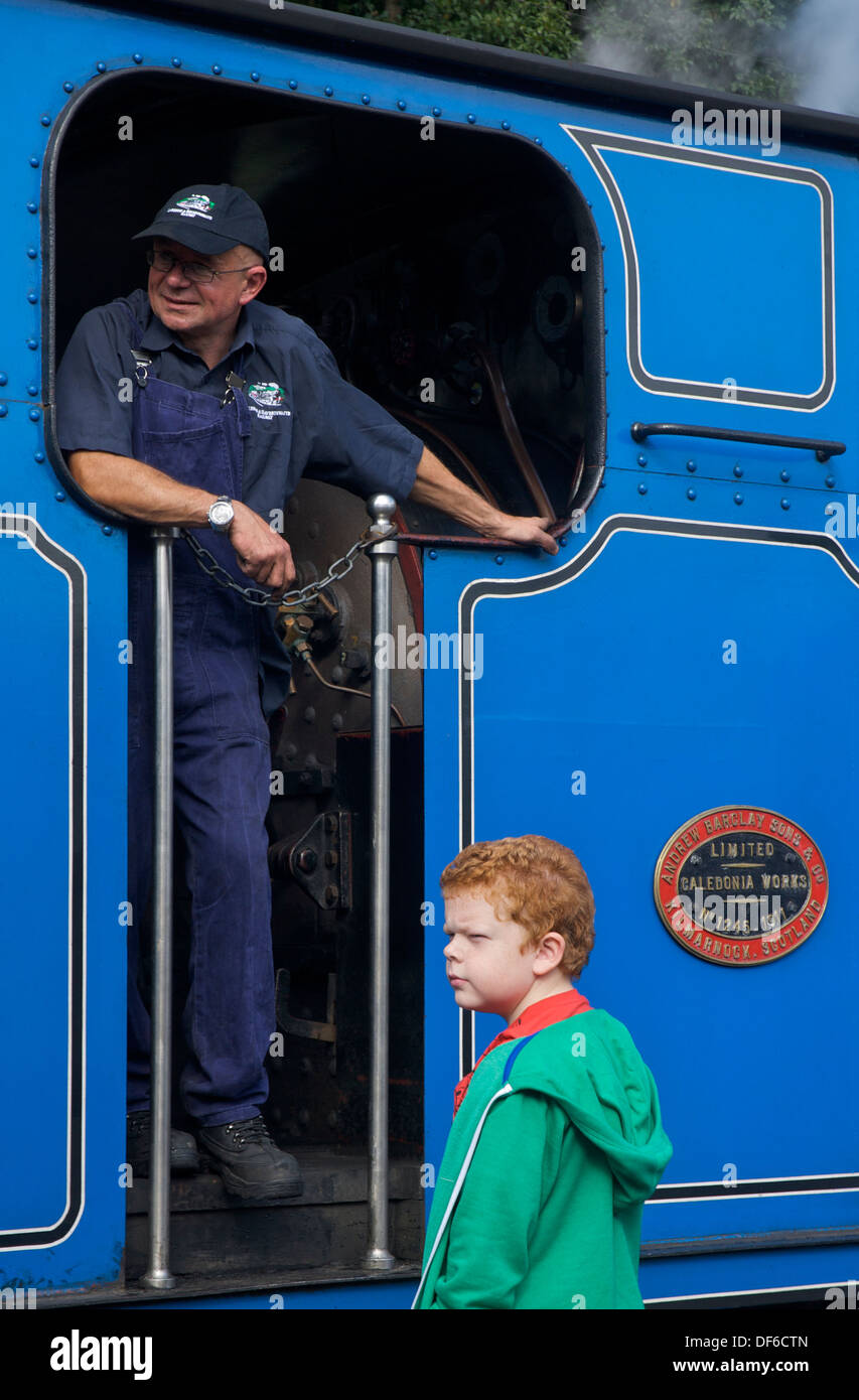 L uomo nella cabina del treno a vapore sul lago & Haverthwaite ferroviarie, Cumbria, England Regno Unito Foto Stock