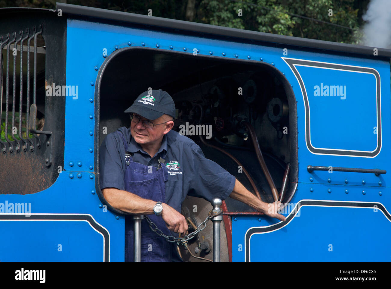 L uomo nella cabina del treno a vapore sul lago & Haverthwaite ferroviarie, Cumbria, England Regno Unito Foto Stock
