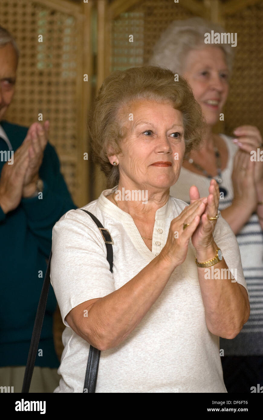 Le donne anziane che mostrano il loro apprezzamento per l'intrattenimento (coro)a macmillan cancer support mattina caffè, surrey, Regno Unito. Foto Stock