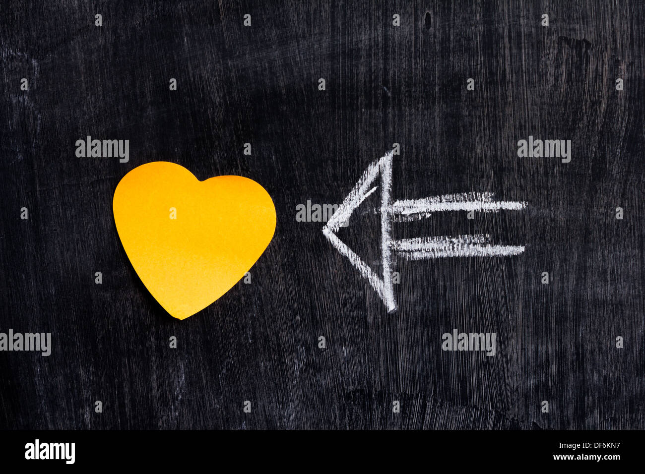 A forma di cuore ad nota sulla lavagna con chalk disegno della freccia Foto Stock