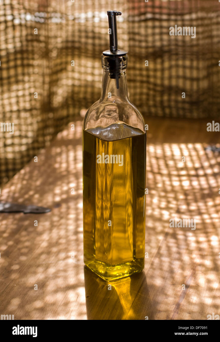 Olio di oliva Bottiglia in una tavola in legno rustico. Foto Stock