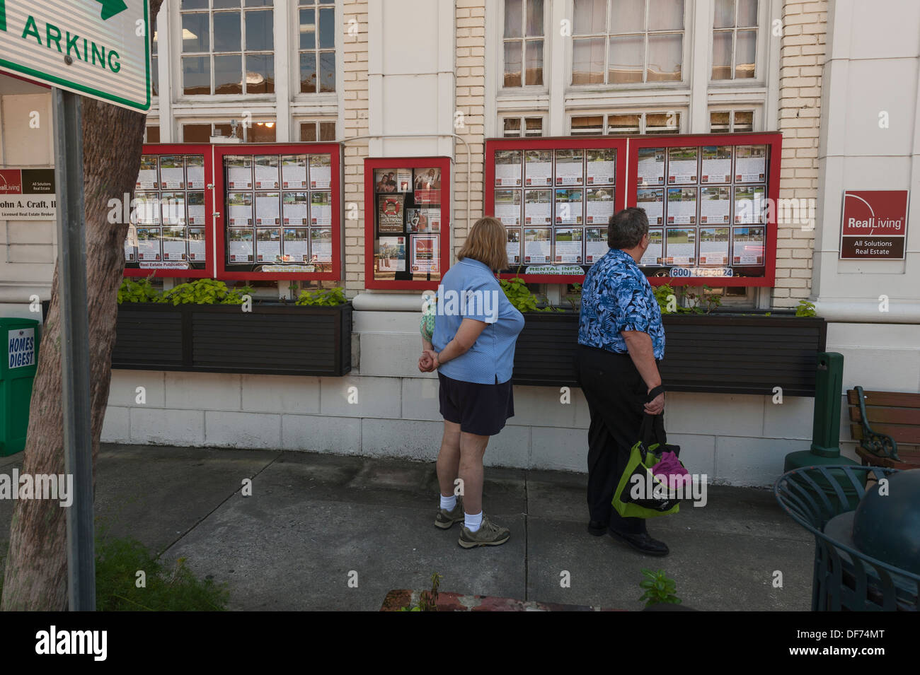 Un giovane checking out Real Estate elencati su una bacheca per la vendita entro la città di Mount Dora, Florida USA Foto Stock