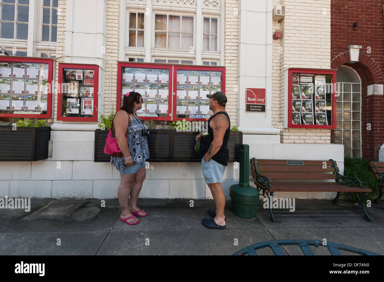 Un giovane checking out Real Estate elencati su una bacheca per la vendita entro la città di Mount Dora, Florida USA Foto Stock