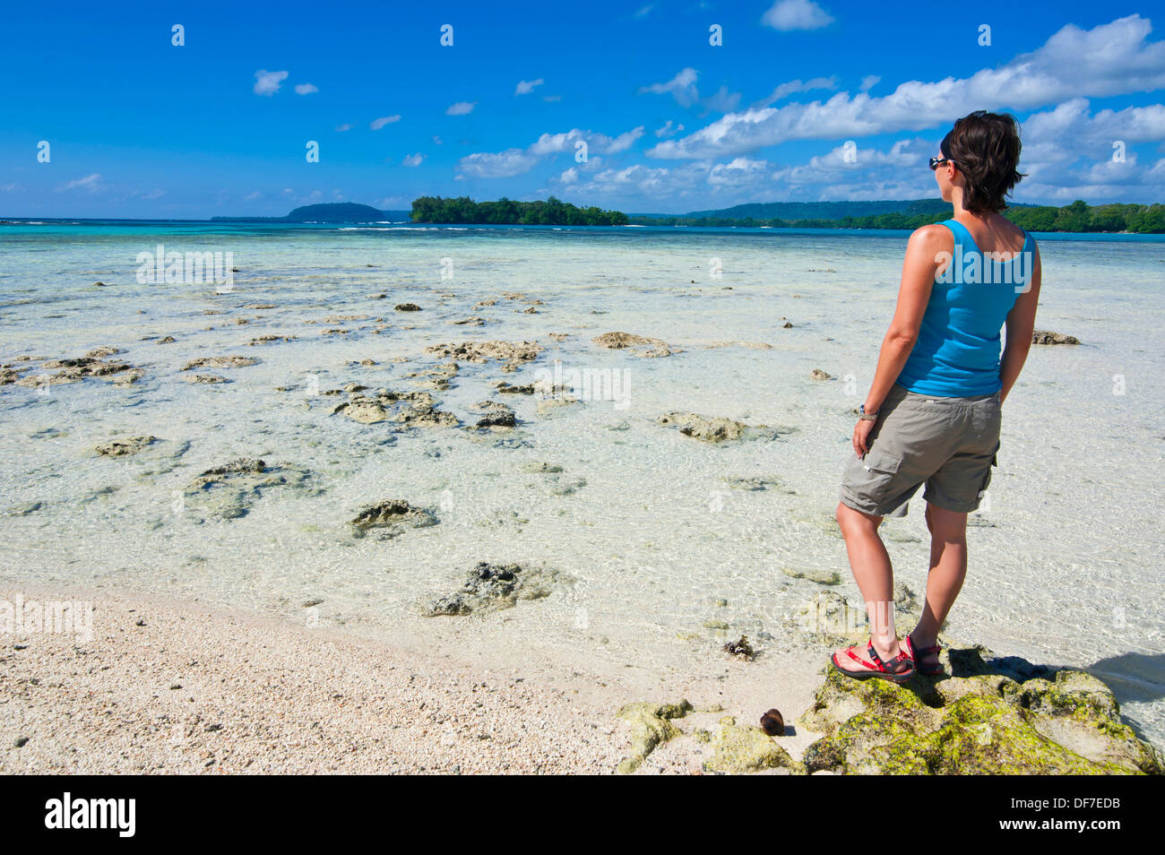 Donna in piedi sulla spiaggia che guarda verso il mare, porto Orly, Espiritu Santo, Sanma Provincia, Vanuatu Foto Stock