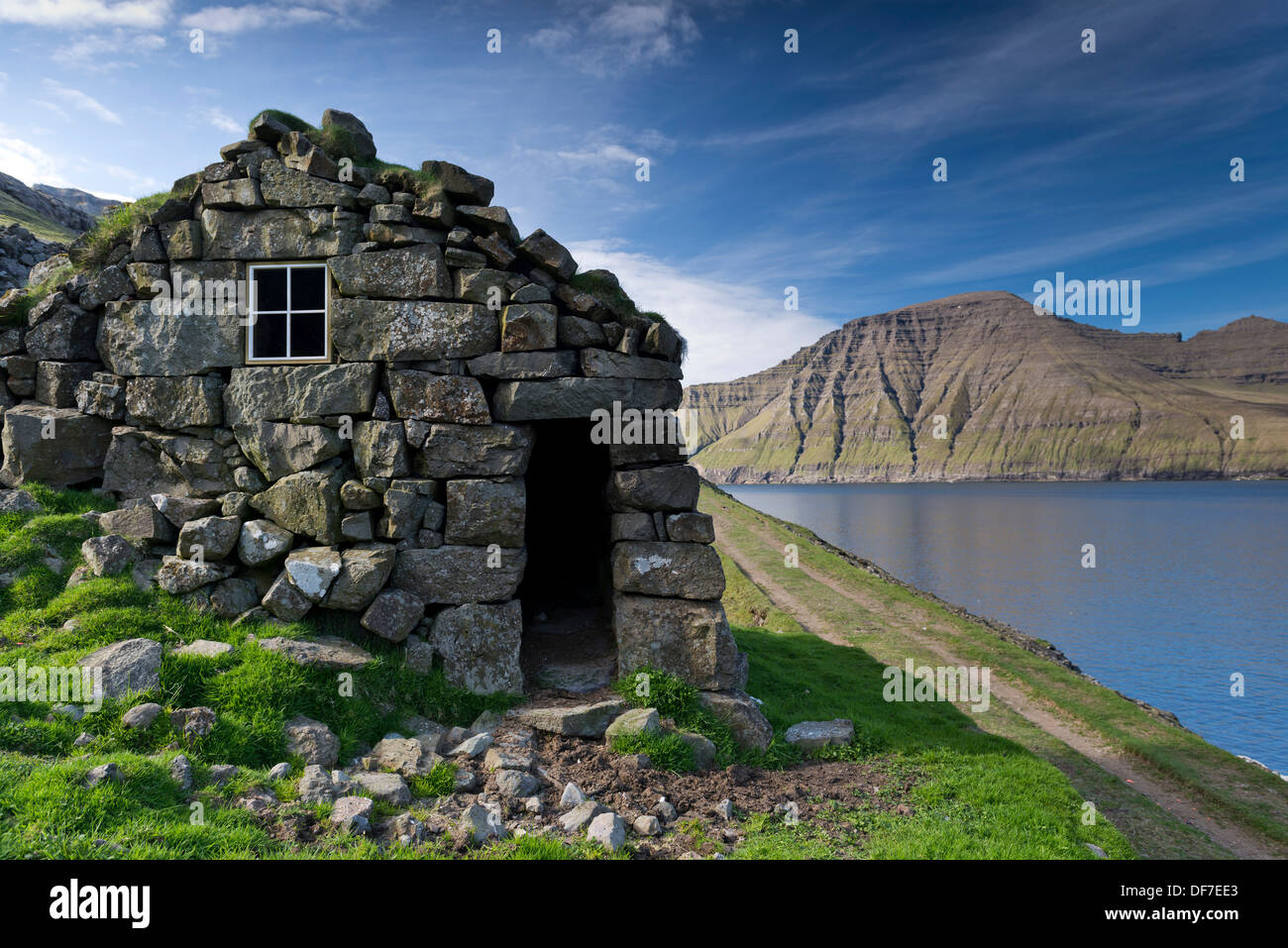 Vecchia casa di pietra su un fiordo, Borðoy, Norðoyar, Isole Faerøer, Danimarca Foto Stock