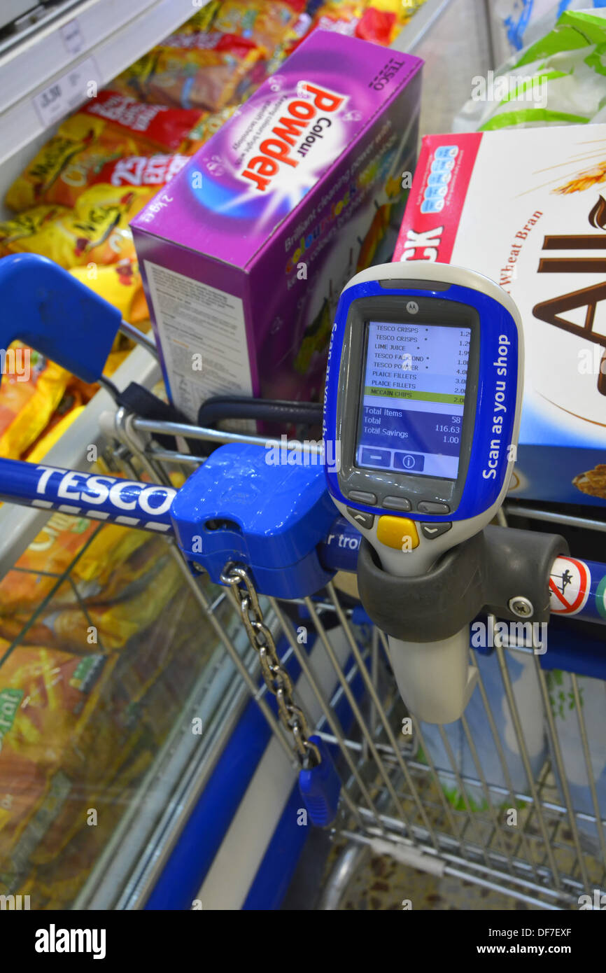 Supermercato Tesco shopper utilizzando palmare 'scan come si acquista il dispositivo per registrare gli elementi acquistati Foto Stock