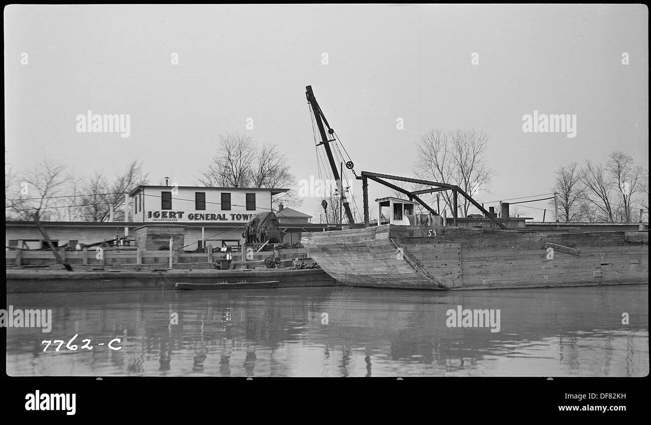 Le imbarcazioni fluviali navigano lungo i terminal, evidenziando il trasporto e l'attività commerciale che si svolge sul fiume come un modo chiave di movimento di merci e passeggeri. Foto Stock