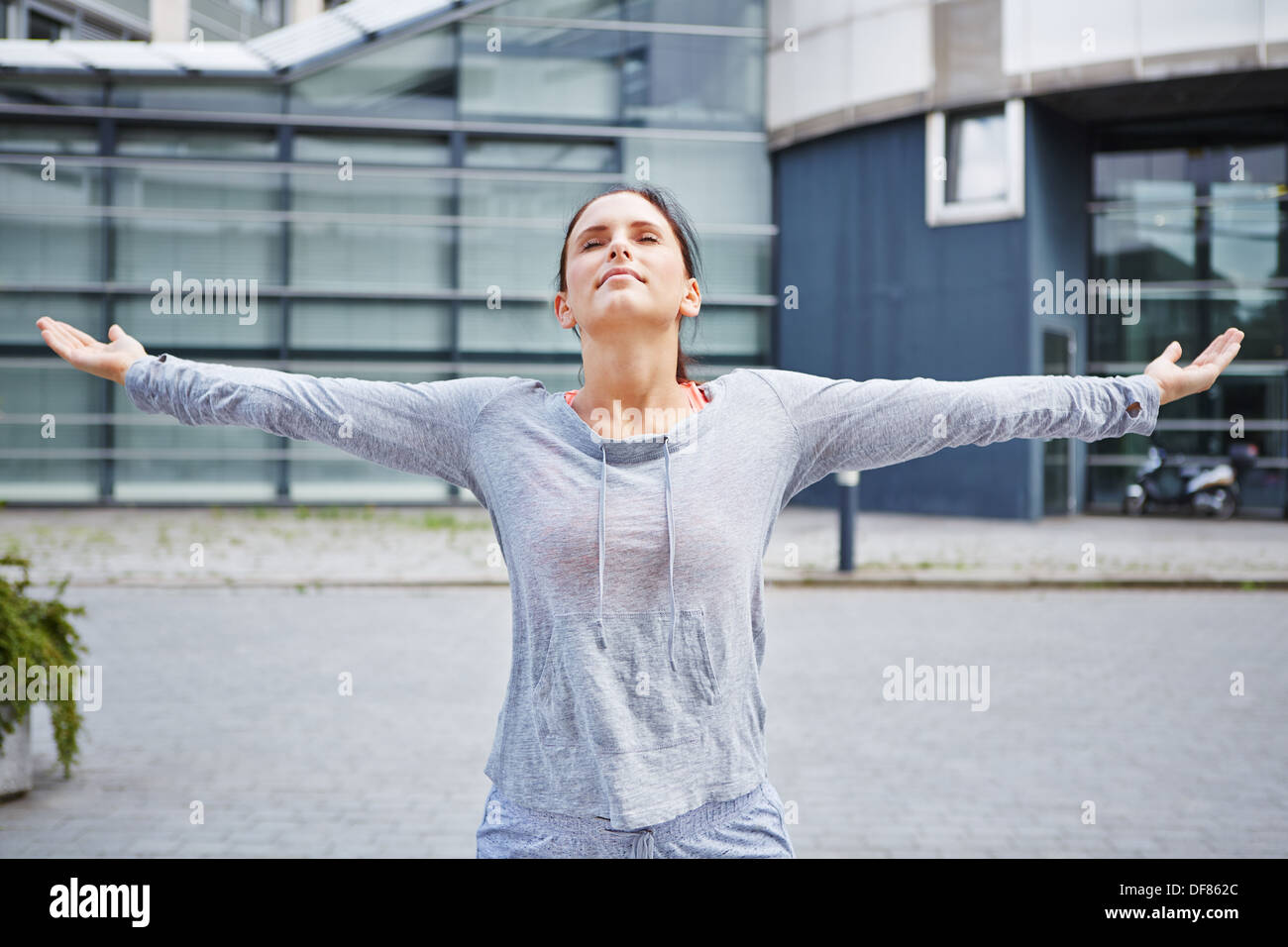 Atletica Giovane donna facendo un esercizio di respirazione in città Foto Stock