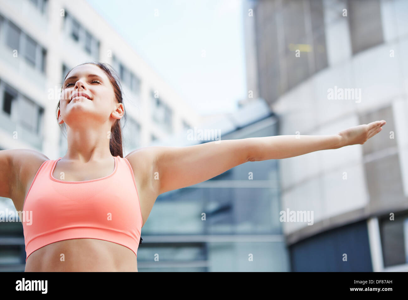 Sportivo da donna facendo esercizio di respirazione per il relax nella città Foto Stock