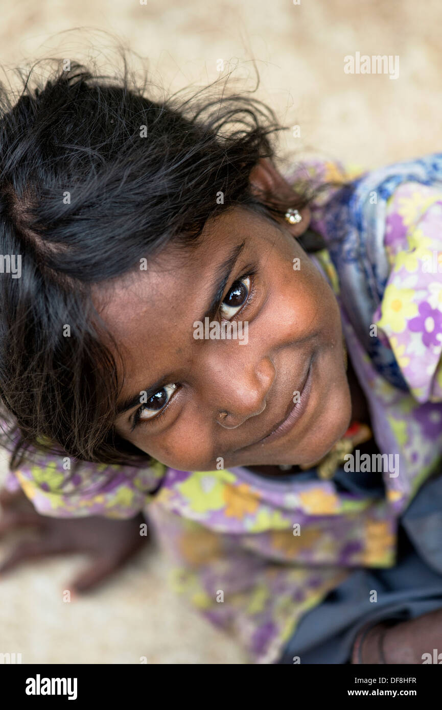 Povero indiano felice ragazza di strada guardando verso l'alto. Il fuoco selettivo. Andhra Pradesh, India Foto Stock