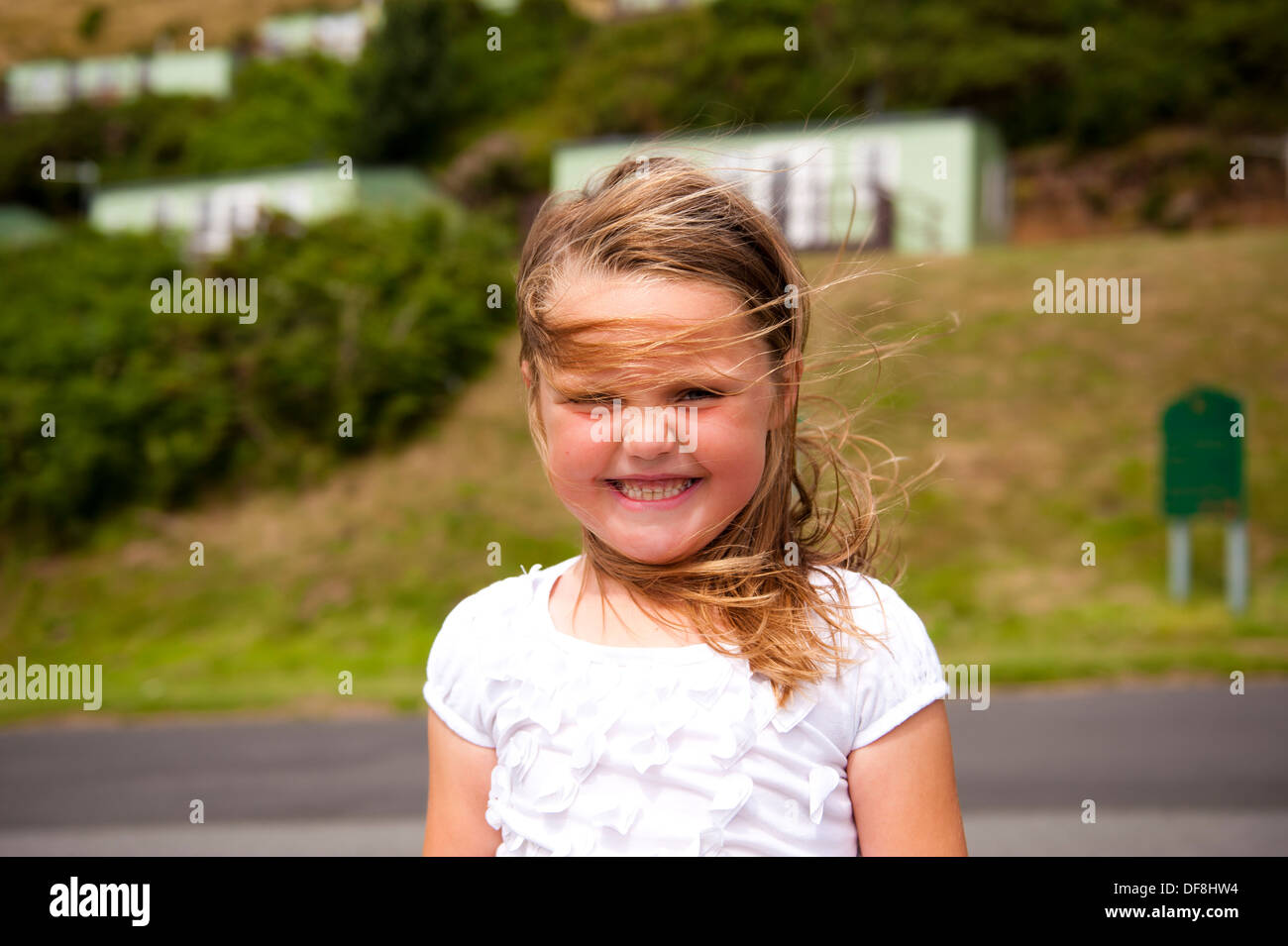 Ragazza al caravan park vacanze con un grande sorriso cercando ventoso Foto Stock