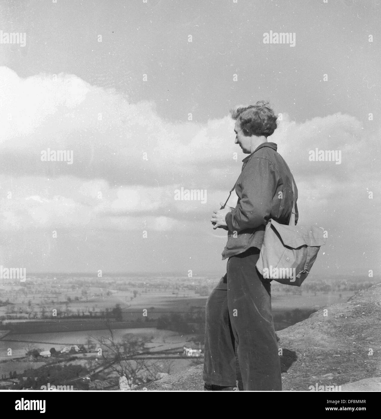Quadro storico,anni cinquanta di una femmina con back pack guardando la vista dalla sulla cima di una collina nel distretto del lago, Inghilterra. Foto Stock