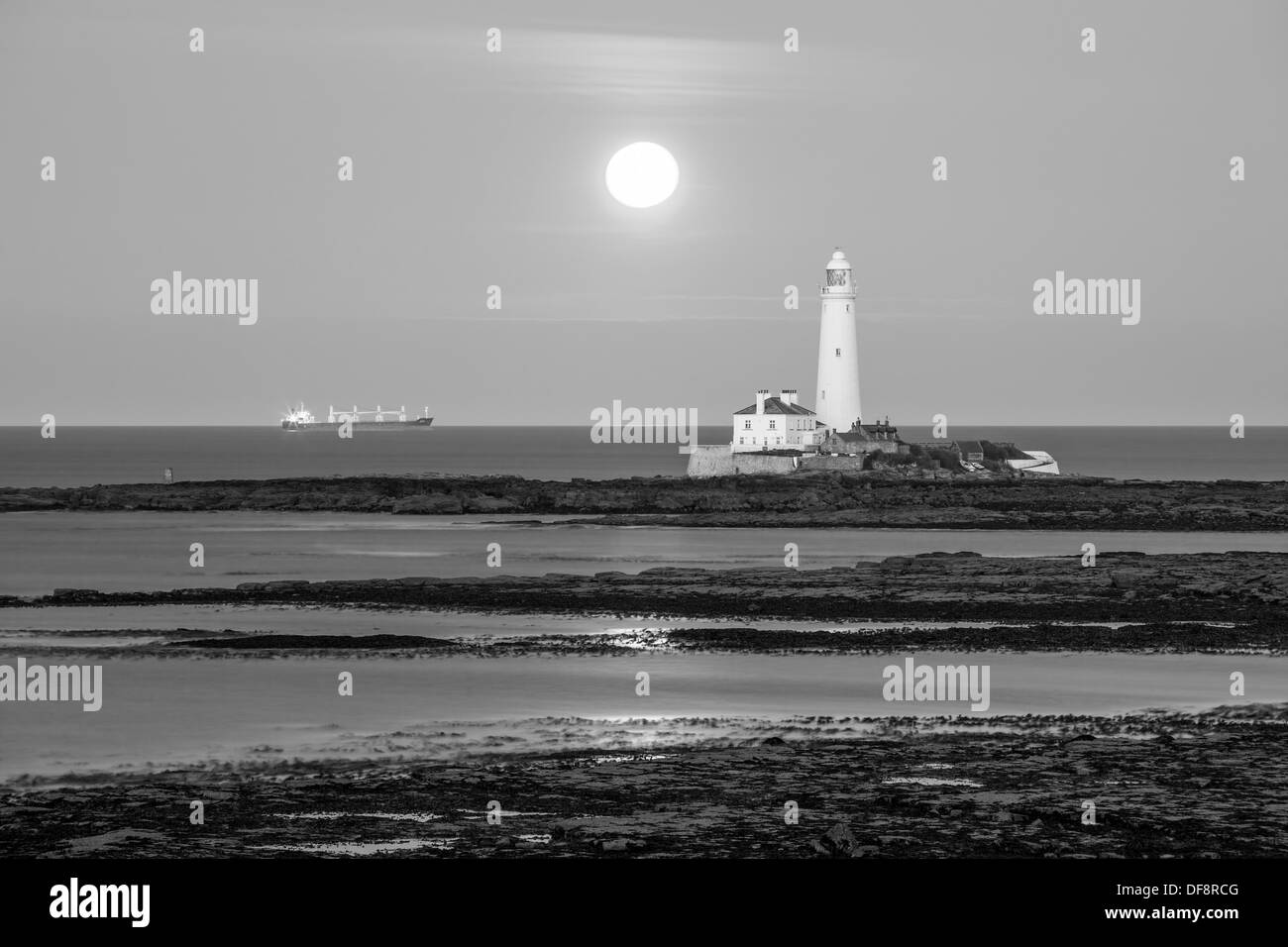 Full Moon Rising su St. Mary's Lighthouse vicino a Whitley Bay, Tyne and Wear. Foto Stock