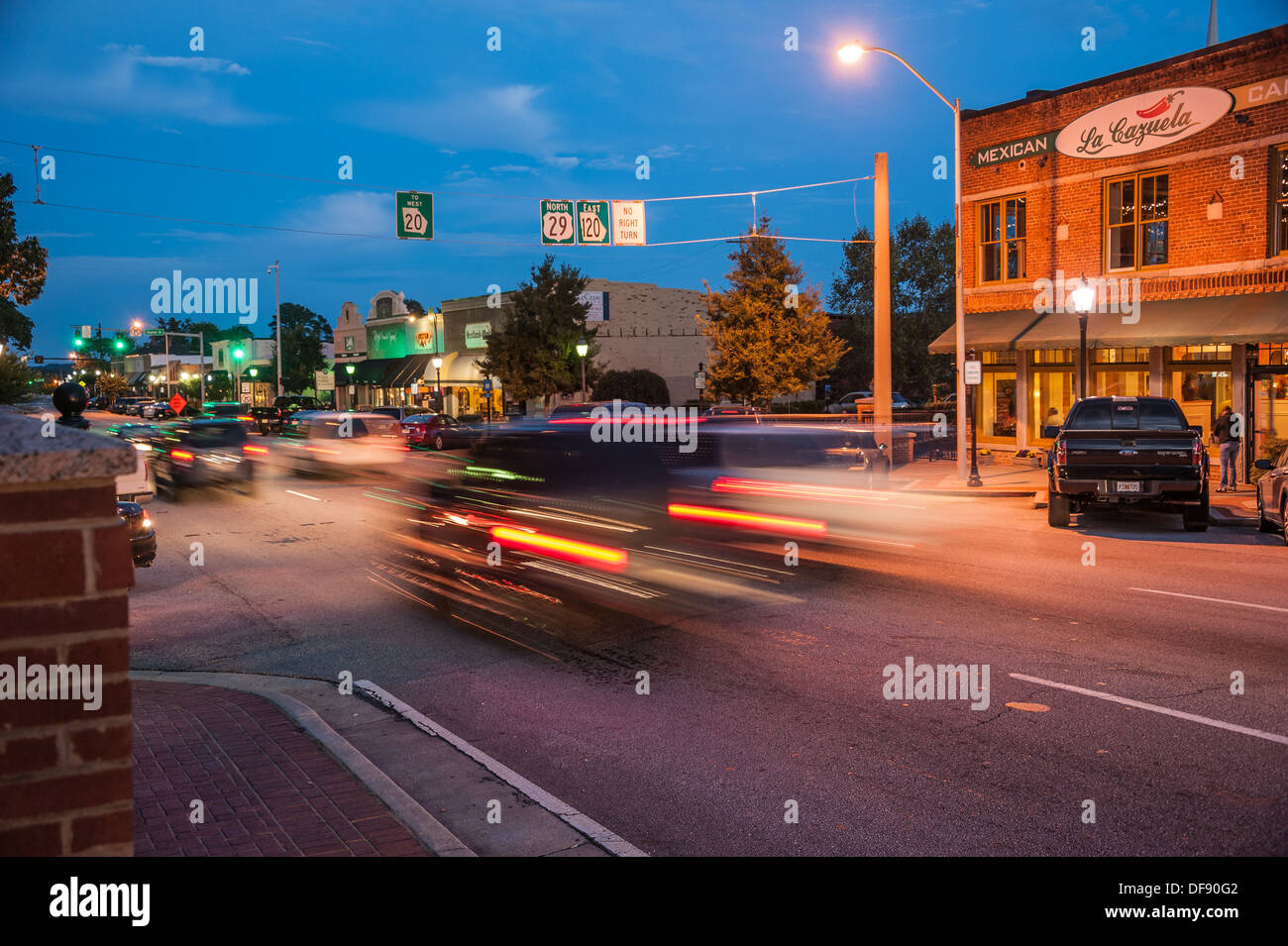 Lawrenceville Square, alla periferia di Atlanta, Georgia, incandescente dalle luci di automobili, negozi e ristoranti. (USA) Foto Stock