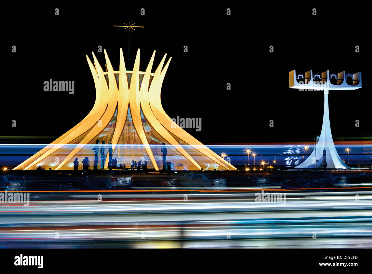 Il Brasile, Brasilia: notturno della cattedrale illuminata con il traffico automobilistico in primo piano Foto Stock