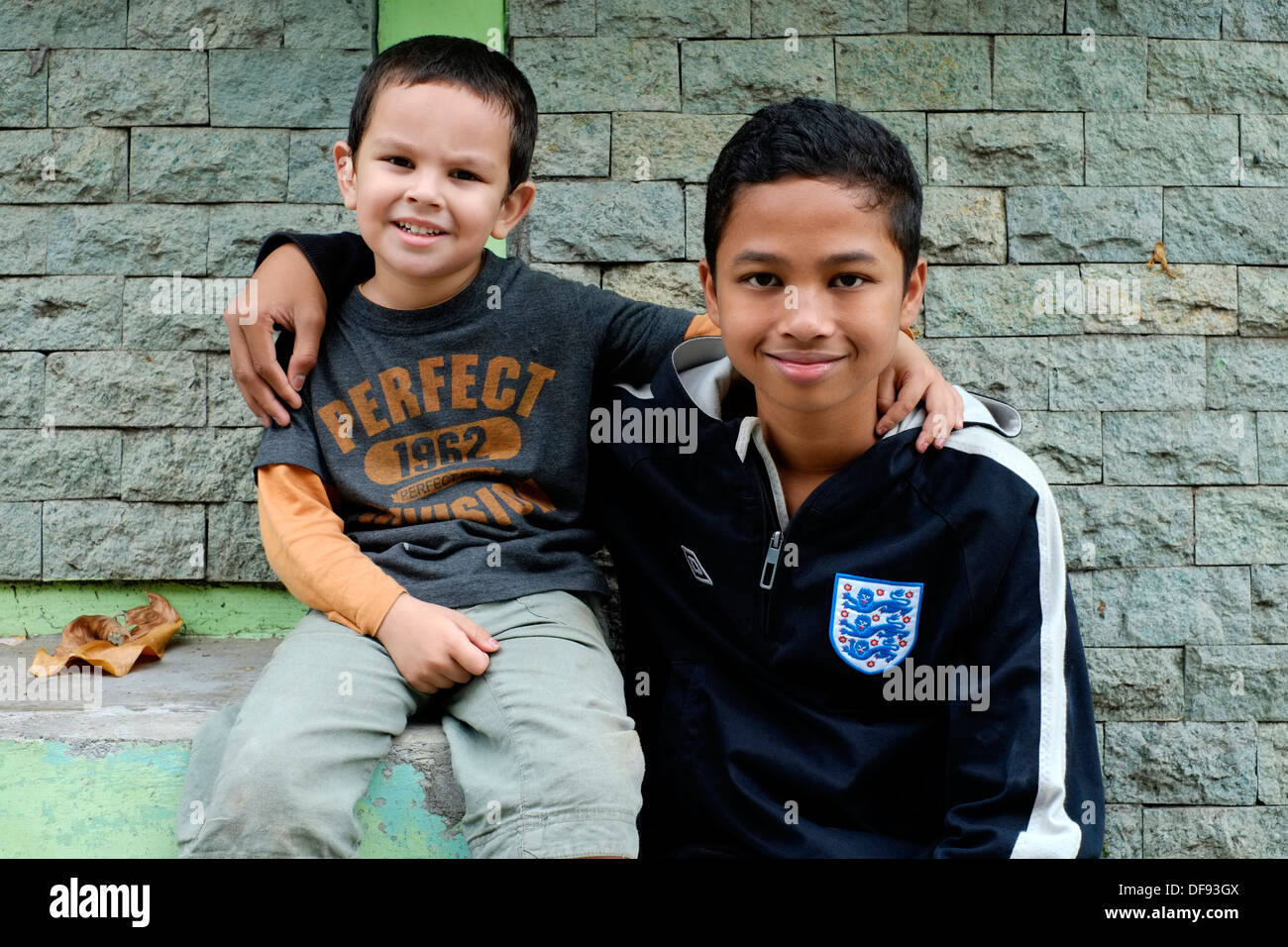 Due metà fratelli uno asiatico una razza mista a divertirsi insieme Foto Stock