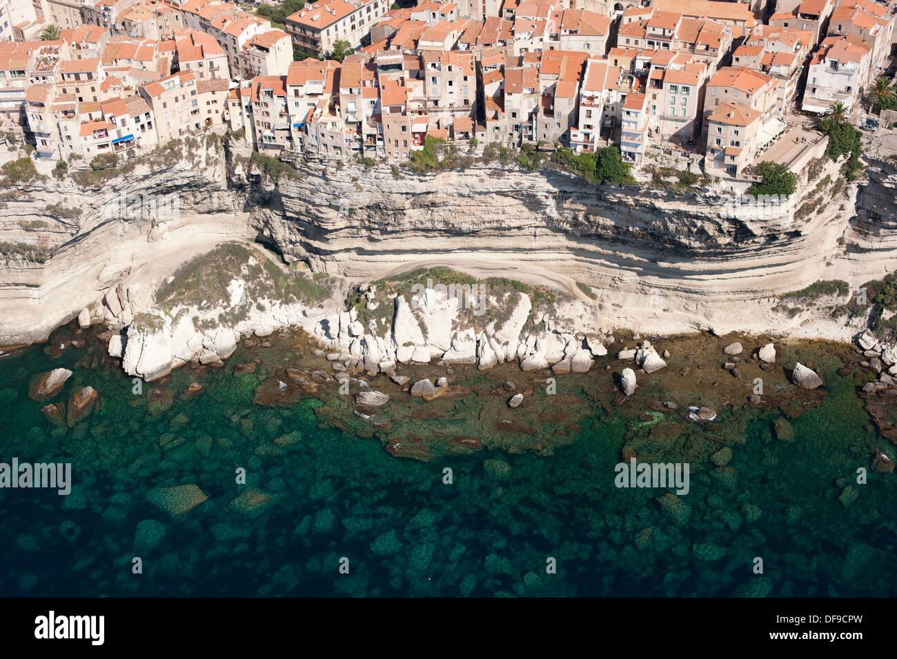 VISTA AEREA. Case sulla cima di una scogliera di pietra calcarea alta sopra il Mar Mediterraneo. Bonifacio, Corsica, Francia. Foto Stock