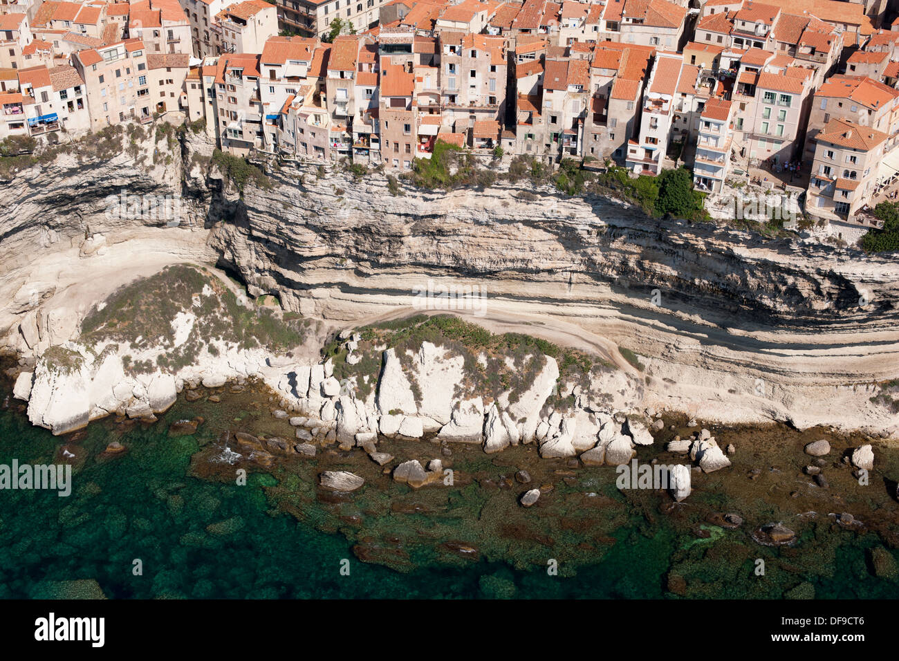 VISTA AEREA. Case sulla cima di una scogliera di pietra calcarea alta sopra il Mar Mediterraneo. Bonifacio, Corsica, Francia. Foto Stock