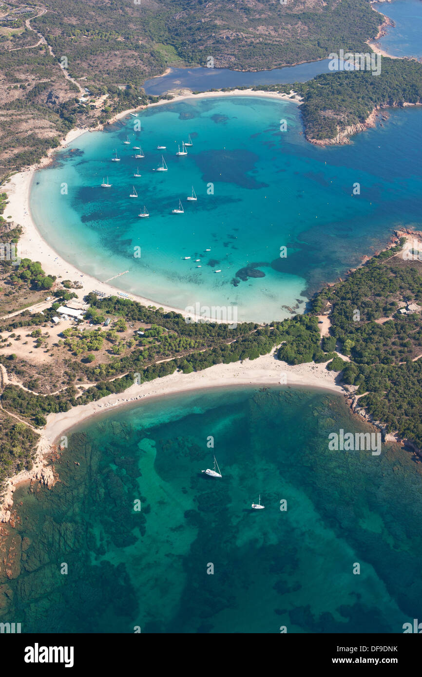 VISTA AEREA. Baia dalla perfetta forma semicircolare e un blu mozzafiato. Golfo di Rondinara, Bonifacio, Corsica, Francia. Foto Stock