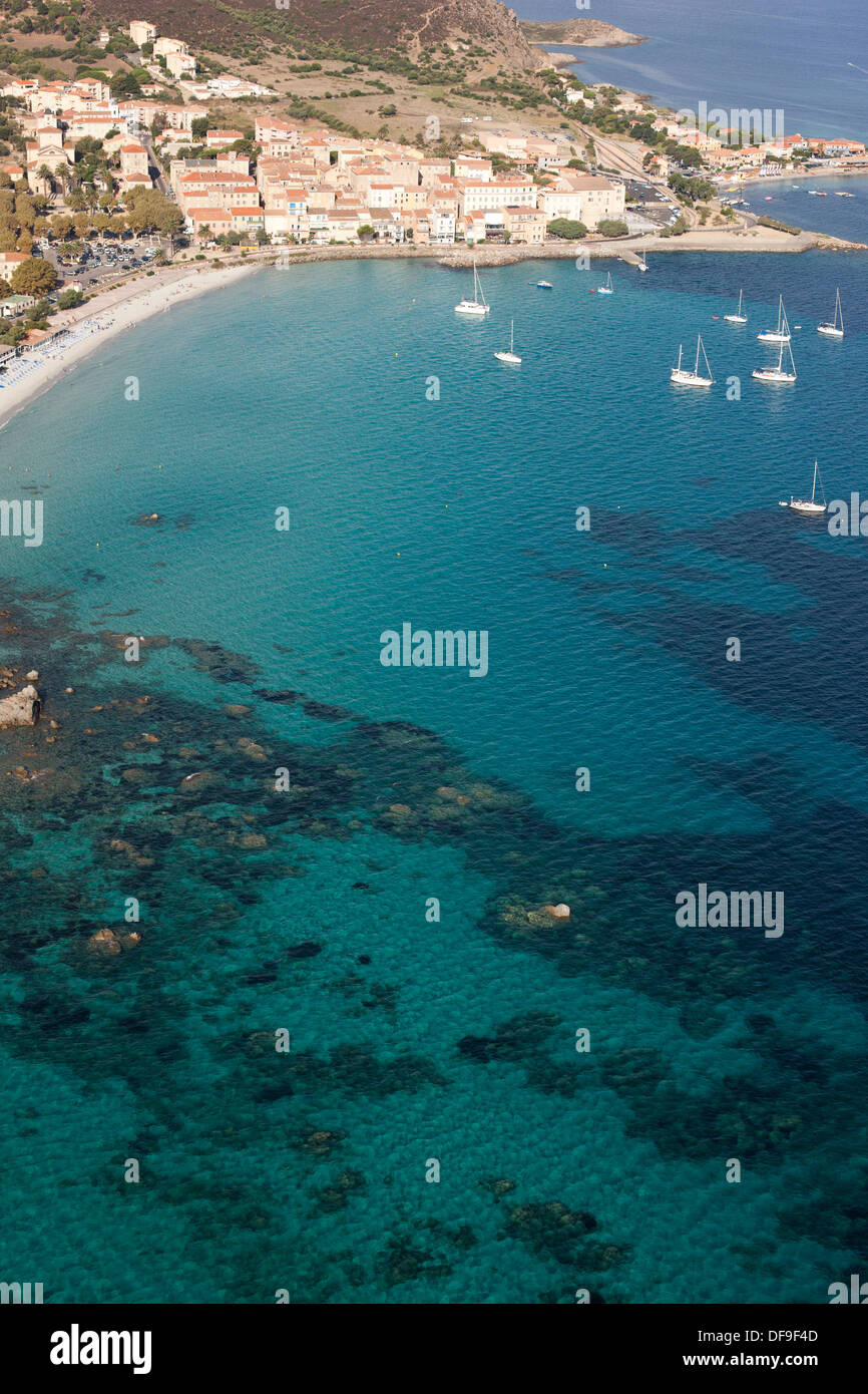 VISTA AEREA. Città di Île Rousse con la sua città vecchia, spiaggia e acqua cristallina. Corsica, Francia. Foto Stock