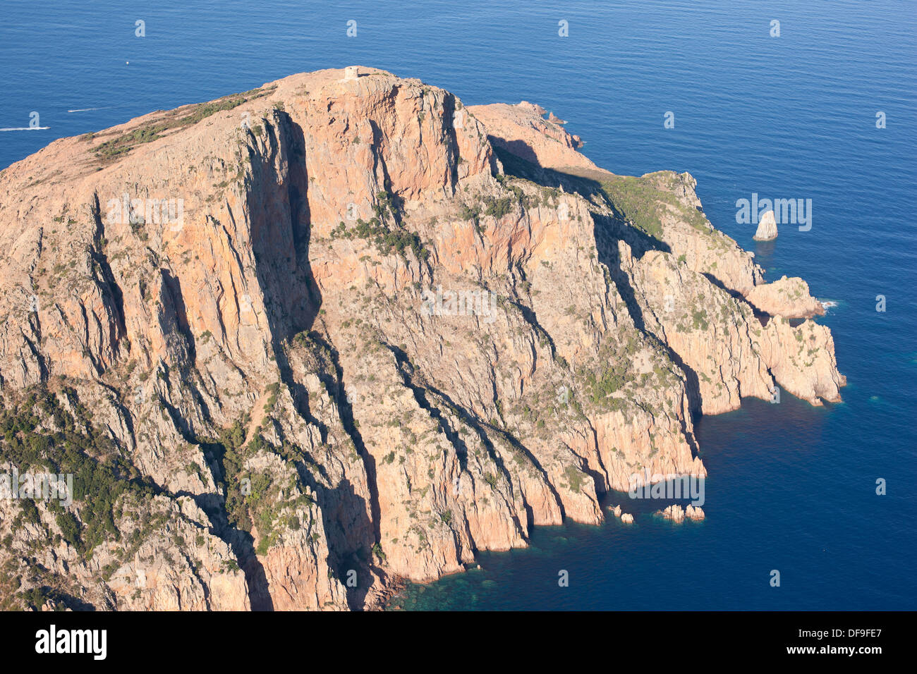 VISTA AEREA. Promontorio roccioso coronato da una torre genovese, alta 331 metri sopra il Mar Mediterraneo. Capo Rosso, noto anche come Capu Rossu, Corsica, Francia. Foto Stock