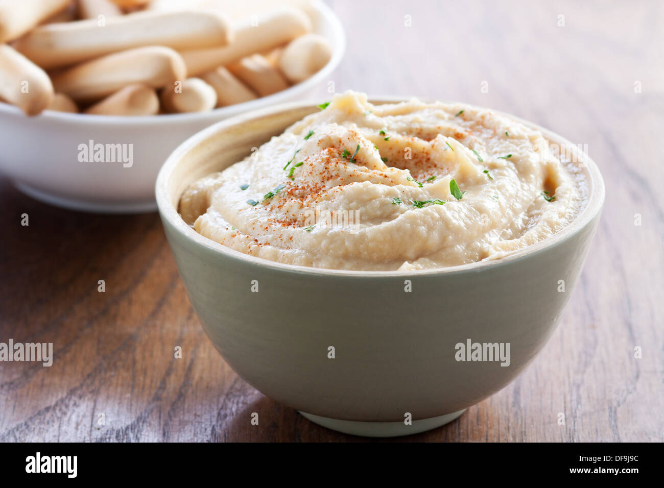 Una deliziosa tazza di ceci hummus con grissini Foto Stock