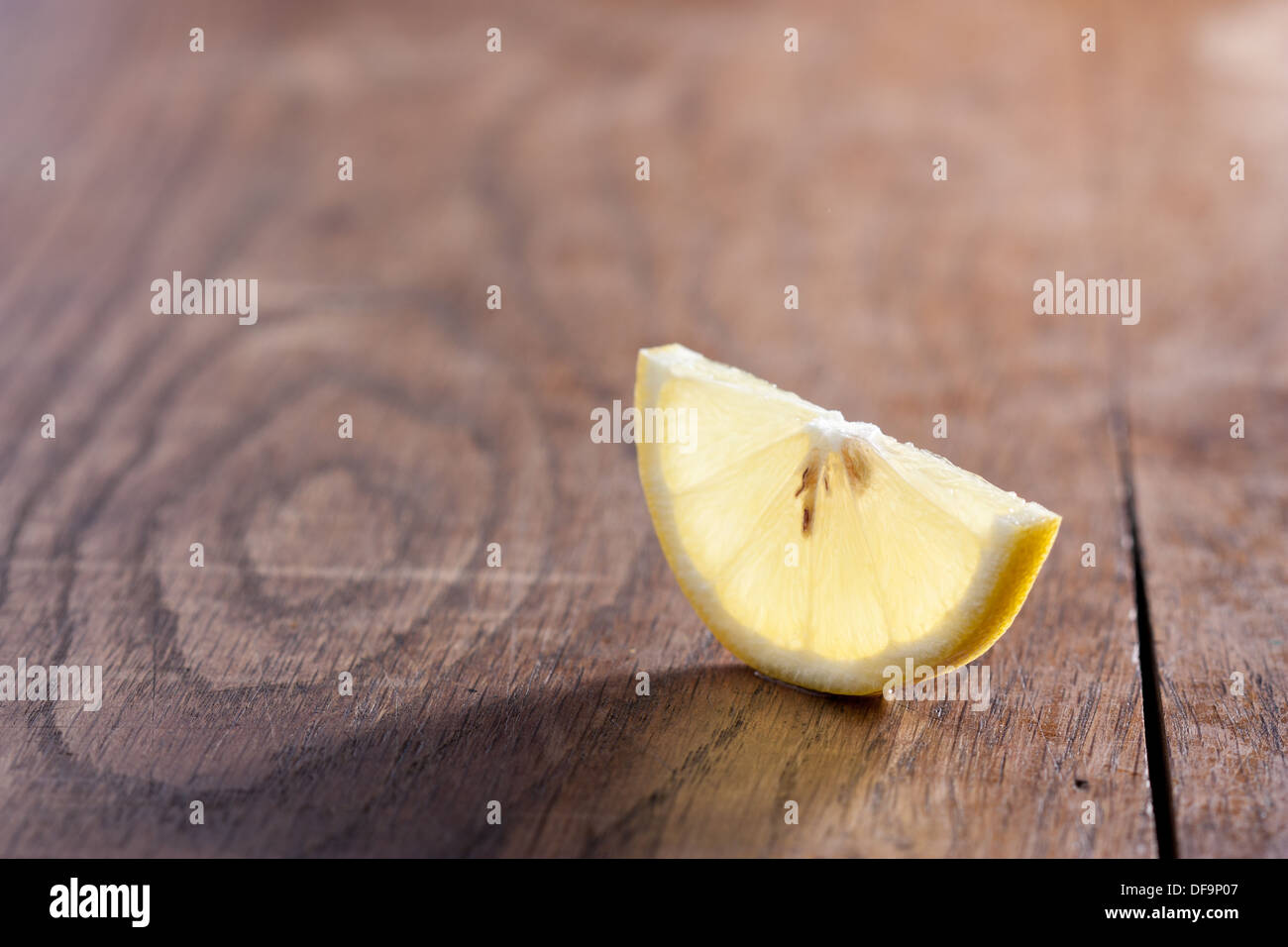 Mezza fetta di limone close-up su una tavola di legno Foto Stock