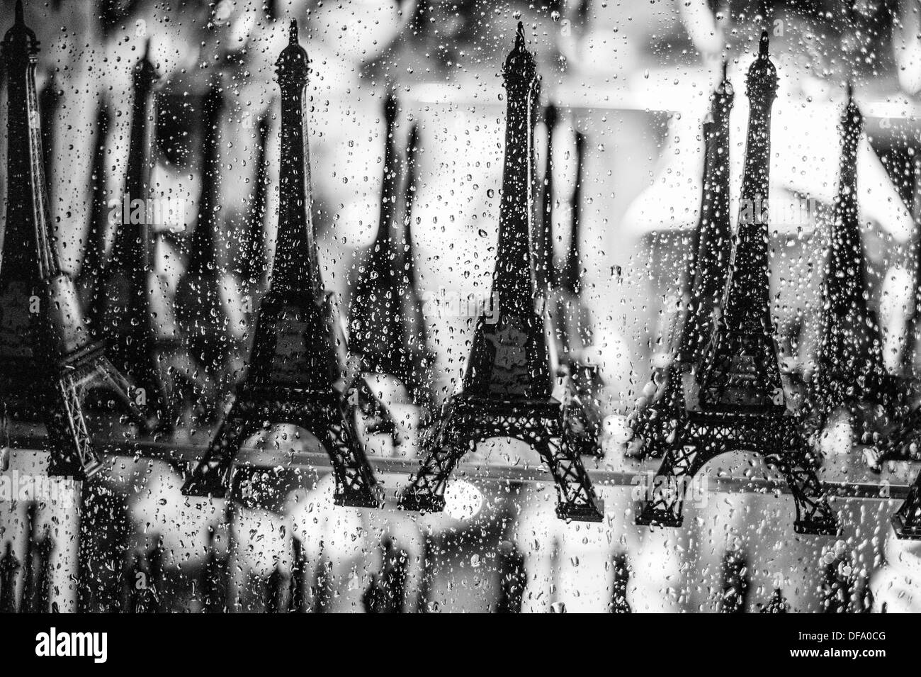 La vetrina del negozio all'interno della torre Eiffel in una piovosa notte con modello di souvenir torri in vendita. Foto Stock