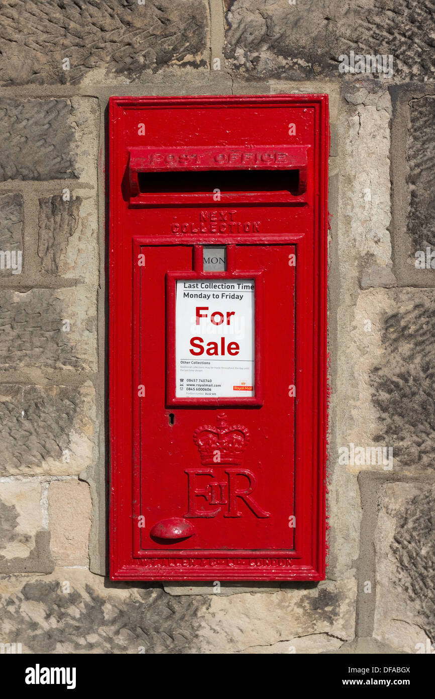 Red Royal Mail Post Box montato in una parete con una vendita di concetto, aggiunto ad essa (immagine manipolata) REGNO UNITO Foto Stock