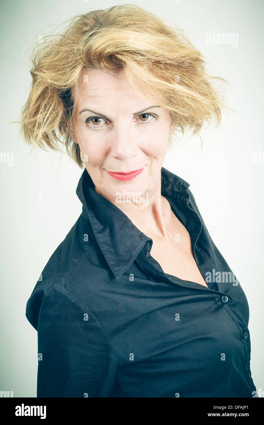Sorridente donna di mezza età con capelli selvaggi Foto Stock