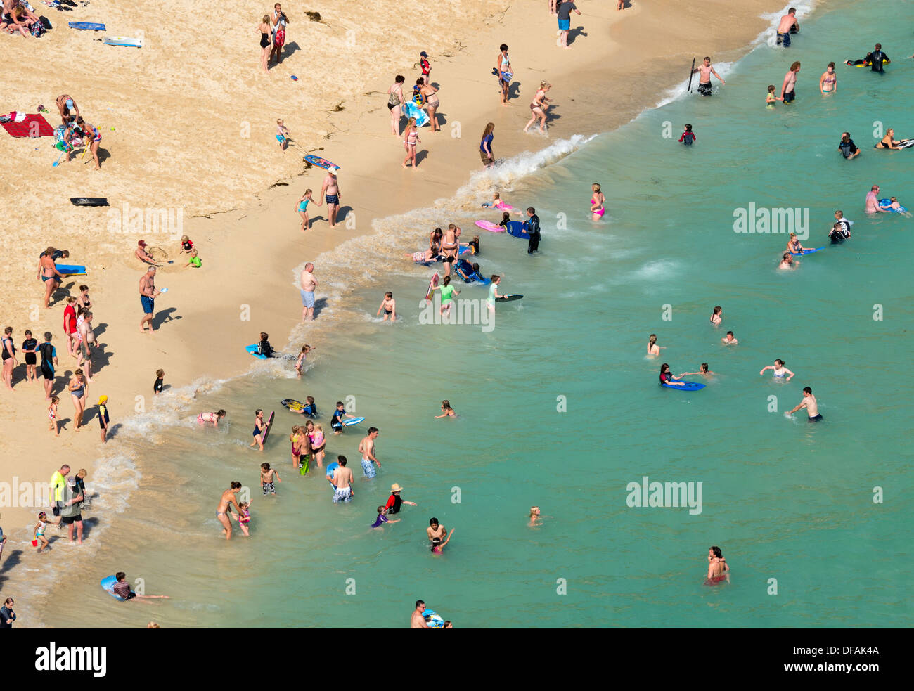 Guardando verso il basso sulla spiaggia Porthcurno sulla riva di una intensa estate scuola giornata di vacanza, Cornwall Inghilterra. Foto Stock