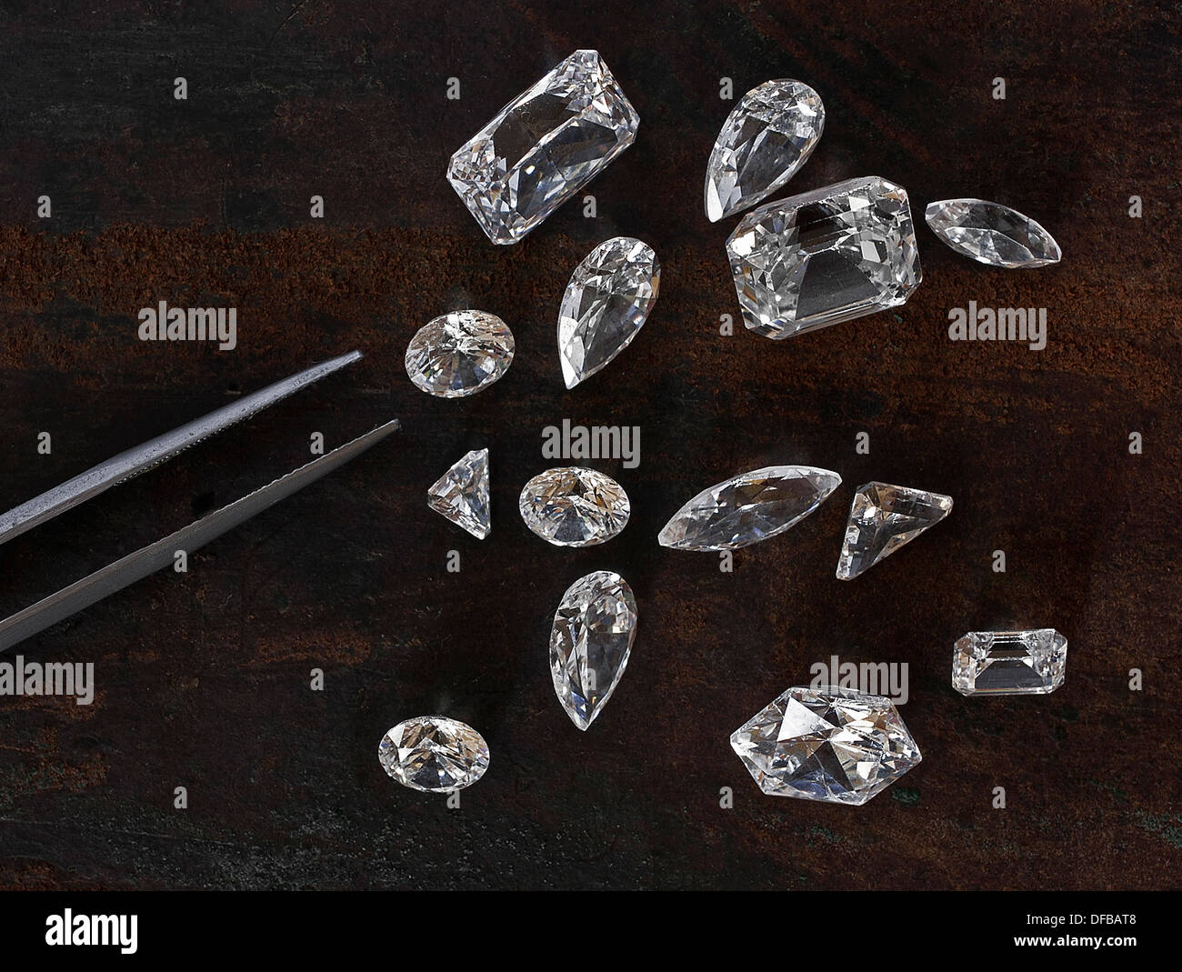 Alcuni diamanti su sfondo in pelle e una pinzetta a molla Foto Stock