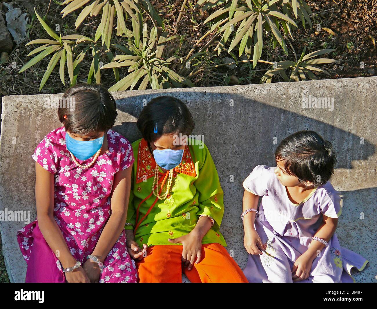 Le piccole bambine in un giardino con precauzione le maschere per l'influenza suina, H1N1 Foto Stock