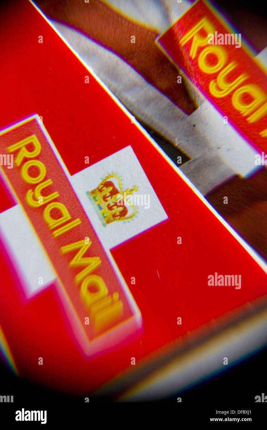 Regno Unito, Londra : un'immagine mostra i libri di Royal Mail prima classe timbri attraverso una lente di ingrandimento. Settembre 12, 2013. Foto Stock