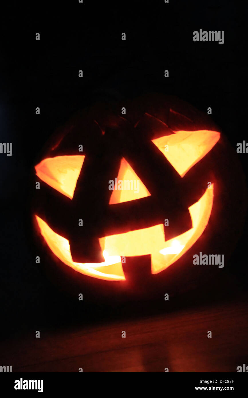 Incandescente Zucca di Halloween in testa su sfondo nero Foto Stock