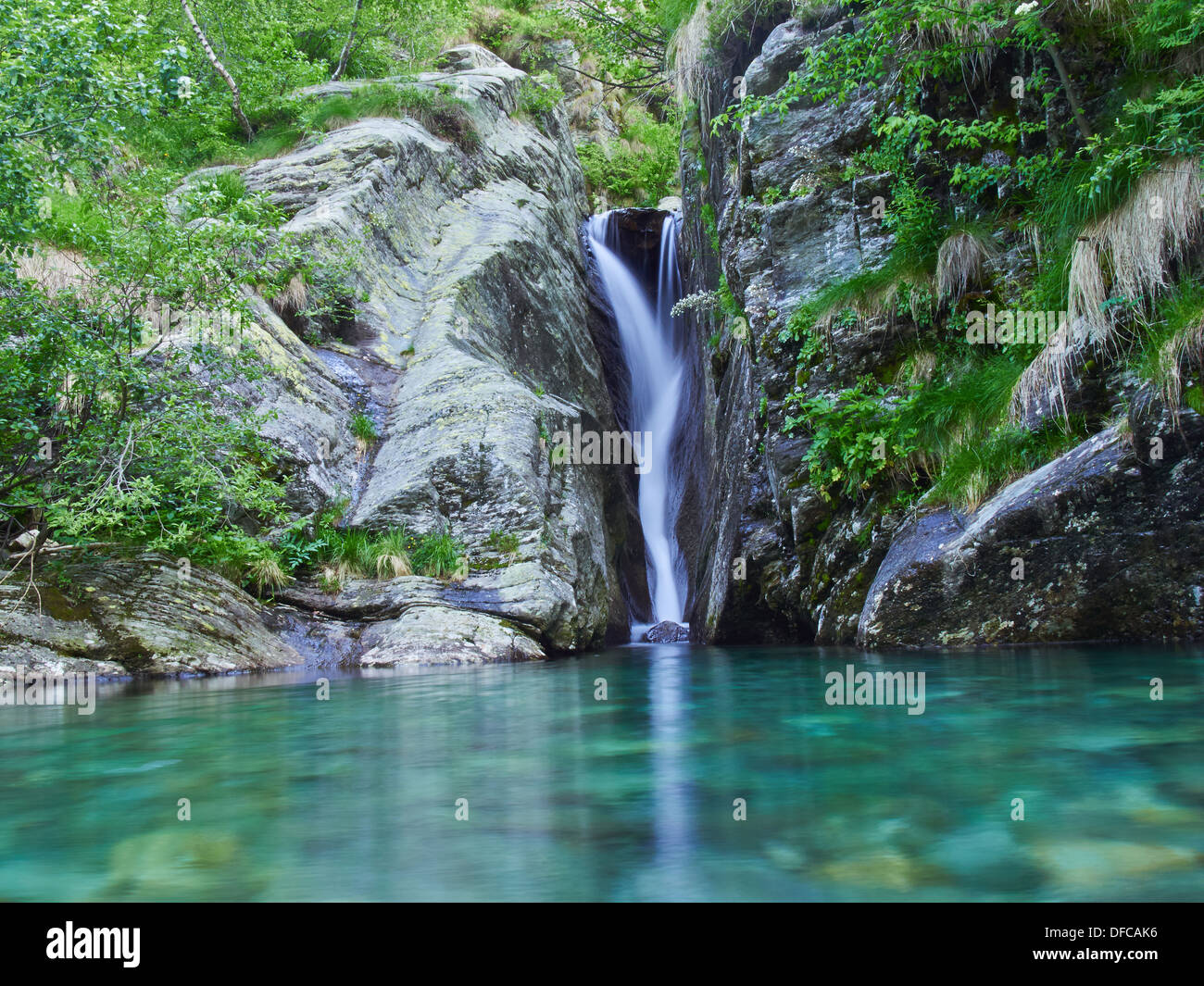 Cascata con piccolo lago delle Alpi italiane nella Valle Grande Foto Stock