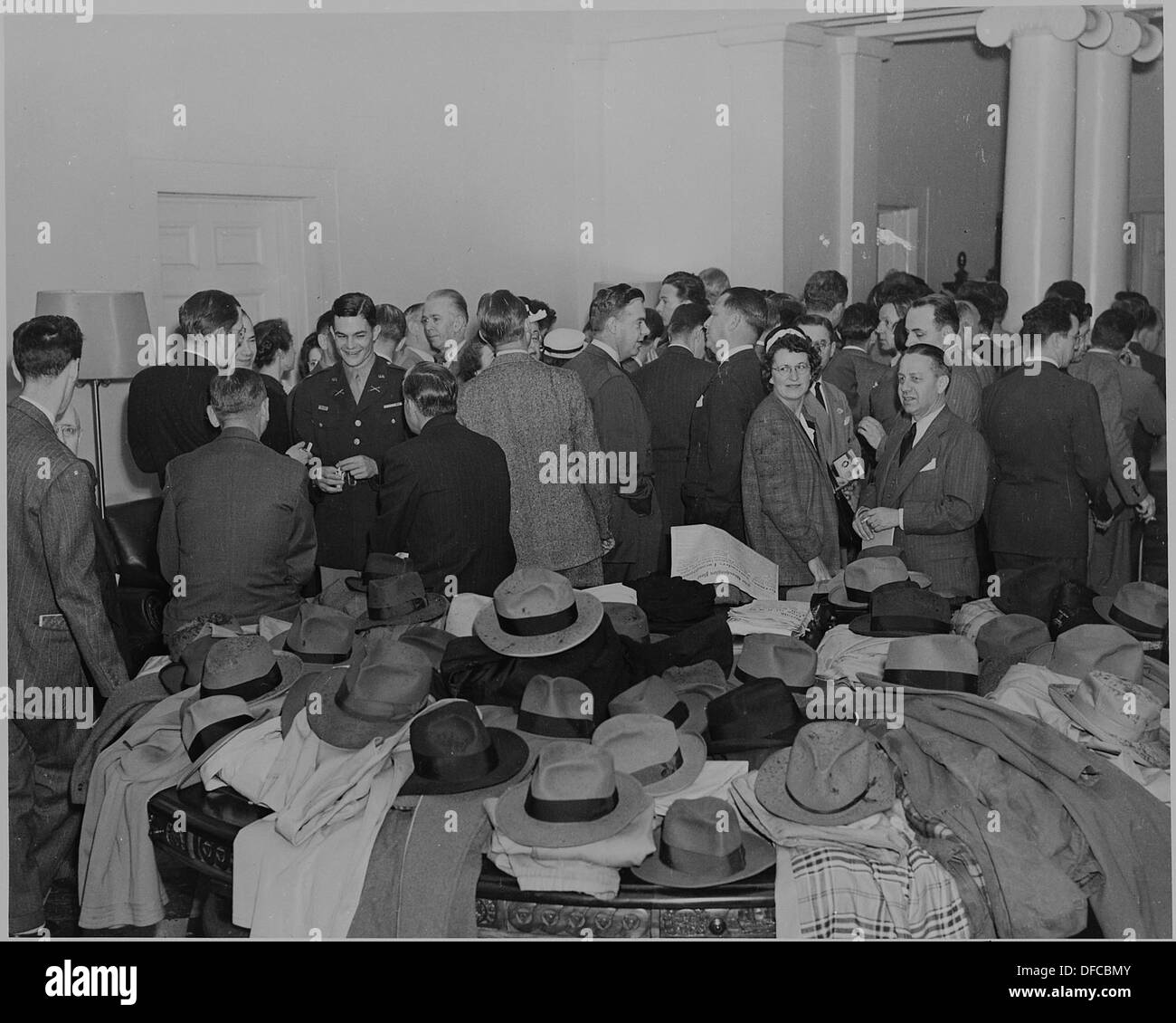 Una piccola folla nella Casa Bianca, i loro cappelli e cappotti impilati su un tavolo, si sono riuniti in occasione dell'announcment... 199080 Foto Stock