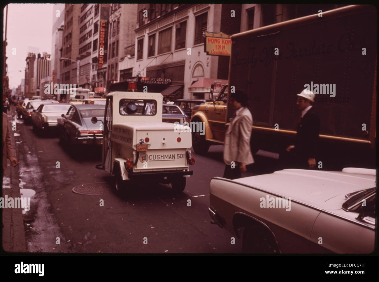 Un mini-camion bianco è visto come parte del traffico giornaliero sulla 47th Street, mettendo in evidenza la scena dei trasporti urbani e i diversi veicoli comunemente presenti sulle strade della città. Foto Stock