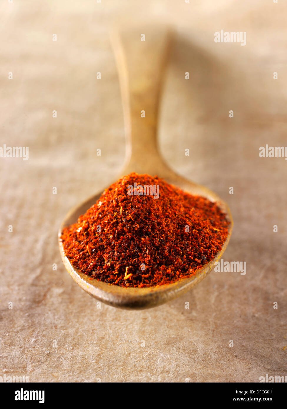 La paprica spezie in polvere in un cucchiaio di legno contro uno sfondo naturale Foto Stock