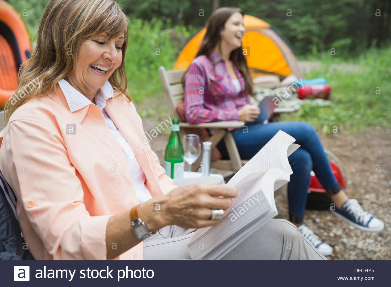 Senior donna libro di lettura al campeggio Foto Stock