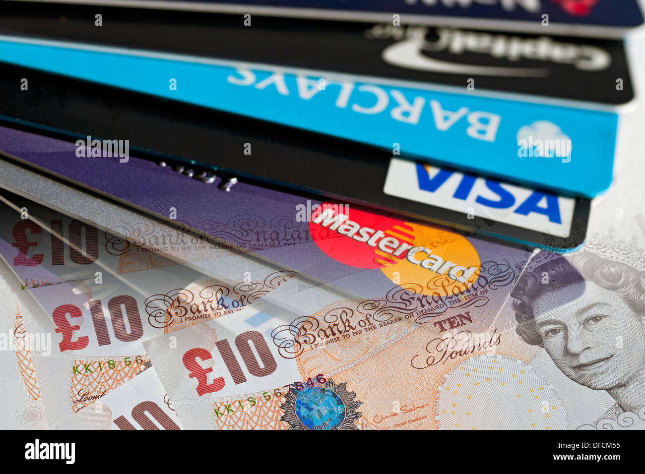 Primo piano di carte di credito bancarie Visa Barclaycard Capital One e banconote in sterline Foto Stock