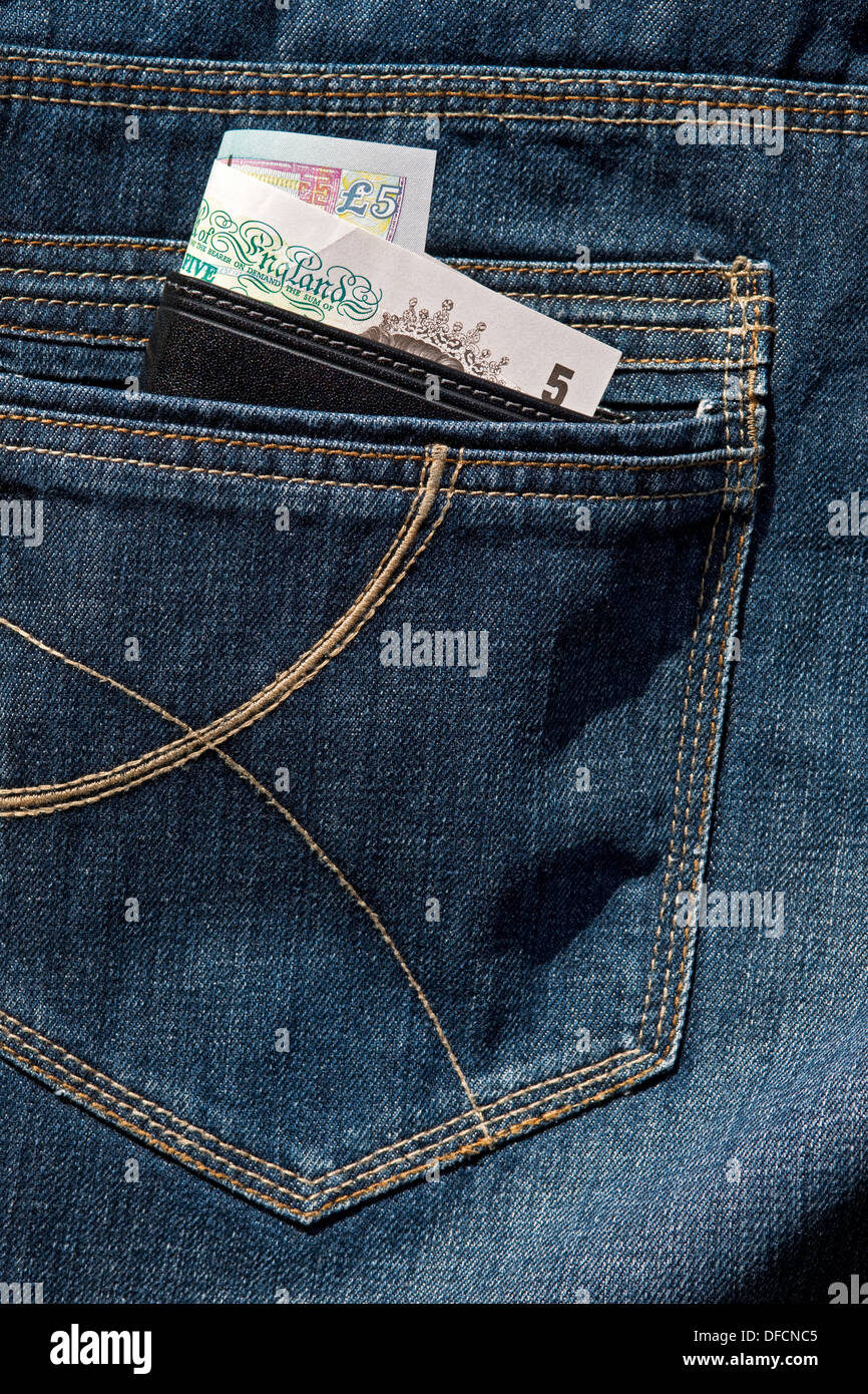 Primo piano di un portafoglio in pelle che mostra banconote in contanti inglesi nella tasca posteriore di jeans in denim e che porta al borseggiamento in Inghilterra e Regno Unito Foto Stock