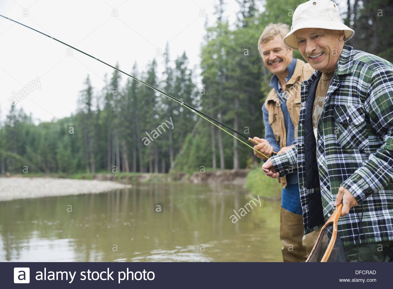 Felice l'uomo senior di pesca con figlio Foto Stock
