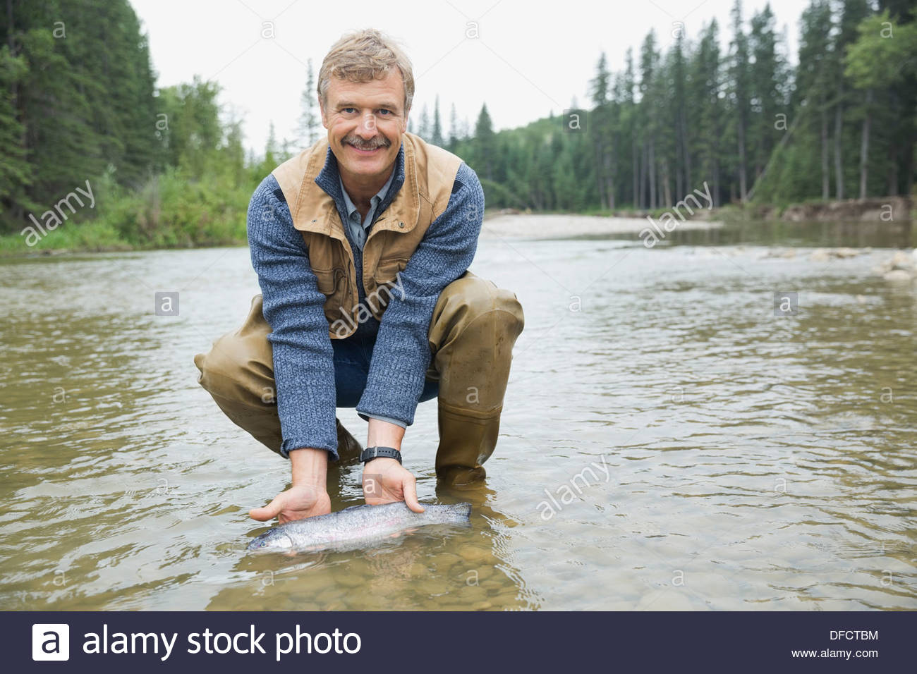 Ritratto di uomo maturo holding pesce pescato Foto Stock